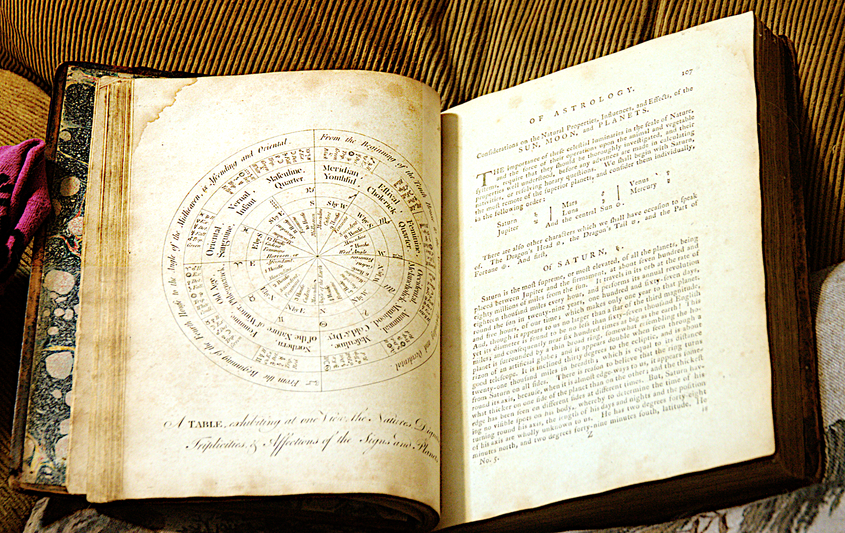 open book showing circular diagam on one page (full-page plate) and text on the other with symbols. The picture is slightly out of focus